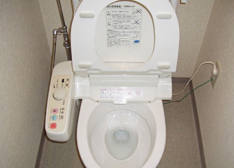 便器の黒ずみや金属部分の水垢を徹底的に磨き上げ、清潔に仕上げられたトイレ