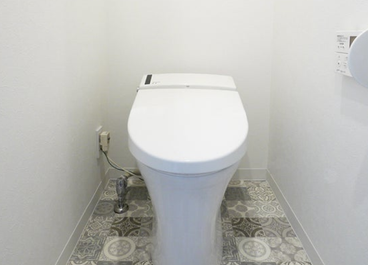 個性的な柄の床材を採用し、遊び心を取り入れたデザインのトイレ空間