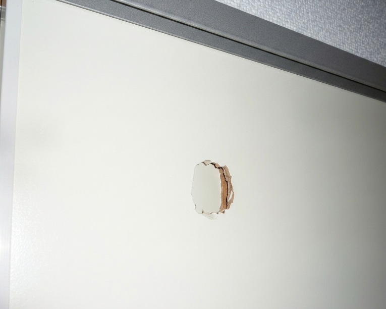 白い壁面にできてしまった、修復前の目立つ凹み傷の様子